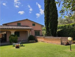 una casa con un patio verde con un árbol en Casale Fonterosa, en Montemerano