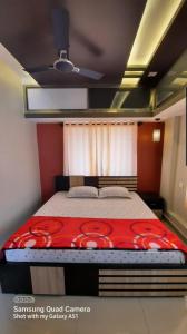 a bedroom with a bed with a red blanket at Varam Homestay in Madikeri