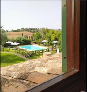 a view of a swimming pool from a window at Casale Fonterosa in Montemerano