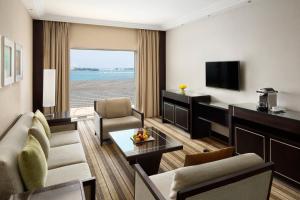 a living room with a couch and a television at Crowne Plaza Jeddah by IHG in Jeddah