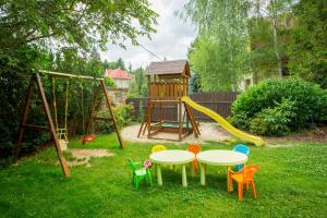 um parque infantil com uma mesa e cadeiras num quintal em Hotel U Pramenu em Plzeň