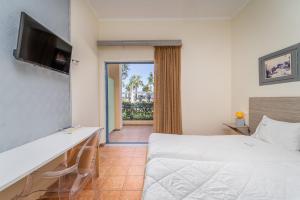 a hotel room with a bed and a sliding glass door at Ianos Hotel in Lefkada Town