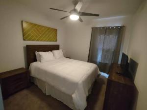 um quarto com uma cama e uma ventoinha de tecto em Cozy 3Bed 2Bath near Mets Stadium/Beach em Port Saint Lucie