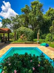 a swimming pool in a garden with a hose at CHÁCARA GODOI - Meu Paraíso in Itu