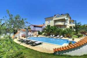 ein Haus mit einem Swimmingpool vor einem Haus in der Unterkunft Apartments Villa Delia in Medulin