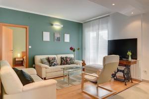 sala de estar con sofá y TV en Apartments Villa Delia, en Medulin
