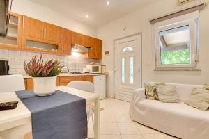 eine Küche und ein Wohnzimmer mit einer Couch und einem Tisch in der Unterkunft Apartments Villa Delia in Medulin