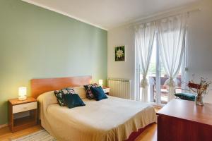 ein Schlafzimmer mit einem Bett und einem großen Fenster in der Unterkunft Apartments Villa Delia in Medulin