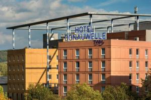 
a large building with a sign on it at Trans World Hotel Donauwelle in Linz
