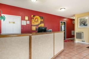 um átrio do hotel com uma recepção e paredes vermelhas em Econo Lodge Jonesboro em Jonesboro