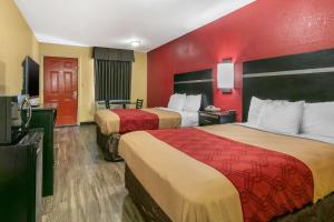 瓊斯伯羅的住宿－瓊斯伯勒伊克諾旅館，酒店客房设有两张床和红色的墙壁。