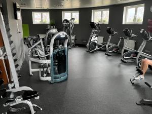 a gym with several treadmills and exercise bikes at Moser Wellness Apartments in Karlovy Vary