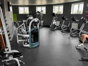 siłownia z kilkoma bieżniami i rowerami treningowymi w obiekcie Moser Wellness Apartment Lux w Karlowych Warach