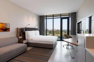 Radisson Blu Hotel & Residence Maputo في مابوتو: غرفة في الفندق مع سرير ومكتب