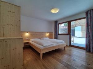 1 dormitorio con cama y ventana grande en Zimmererhof en Bressanone