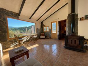 a living room with a fireplace and a large window at Casa Rural El Carrizal in Riópar