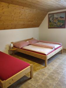 two beds in a room with wooden ceilings at apartmány pod Vysákem in Stárkov