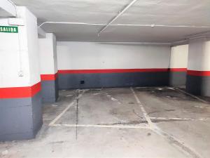 un garage vide avec un mur rouge et blanc dans l'établissement Mendebaldea Suite Premium, à Pampelune