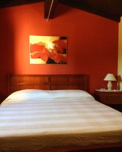 a bedroom with a bed and a red wall at B&B Badde Cubas in Usini