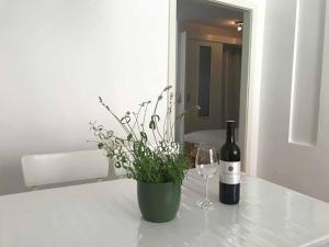 a bottle of wine and a vase with a plant at Gästehaus Lurger in Krems an der Donau
