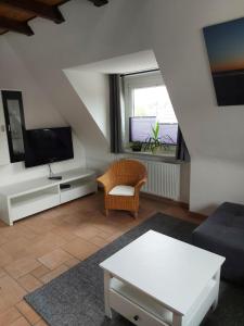 ein Wohnzimmer mit einem Sofa und einem TV in der Unterkunft Ferienwohnung Strandnah in Cuxhaven