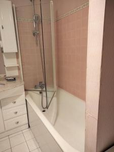 a bathroom with a shower and a bath tub at couchers de soleil en normandie in Trouville-sur-Mer