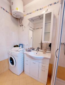 a bathroom with a washing machine and a sink at Villette Susanna in Lignano Sabbiadoro