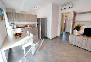 a kitchen with a table and a stainless steel refrigerator at Villette Susanna in Lignano Sabbiadoro