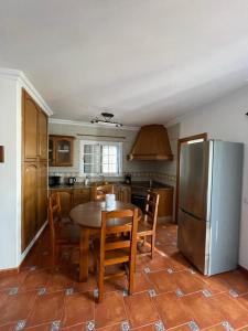 a kitchen with a table and a stainless steel refrigerator at Casa Cueva de los Verdes in Punta de Mujeres