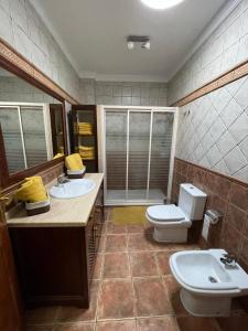 a bathroom with two sinks and a toilet in it at Casa Cueva de los Verdes in Punta de Mujeres