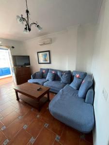 a living room with a blue couch and a table at Casa Cueva de los Verdes in Punta de Mujeres