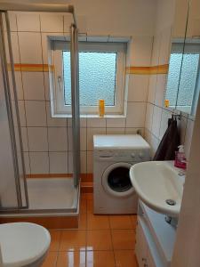 ein Badezimmer mit Waschmaschine und Waschbecken in der Unterkunft Ferienwohnung Strandnah in Cuxhaven