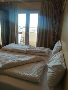 two beds in a room with a window at Philae Hotel Aswan in Aswan