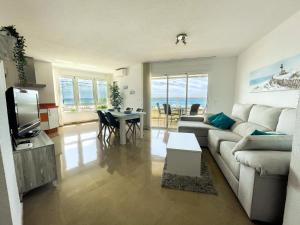 un soggiorno con divano e tavolo di Frontal Apartment First Line a Torrox Costa