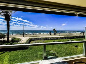 una finestra con vista sulla spiaggia di Frontal Apartment First Line a Torrox Costa
