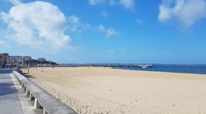 a sandy beach with a pier in the water at Charmant studio in Arcachon