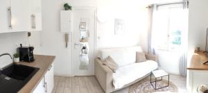 a white living room with a couch and a window at Charmant studio in Arcachon