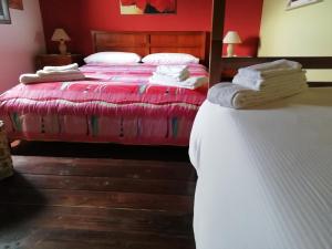 1 dormitorio con 2 camas y paredes de color rojo en B&B Badde Cubas, en Usini