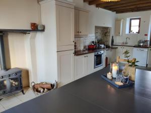 a large kitchen with a counter top and a stove at Chambres d'hôtes / B&B Chez Mon Rêve in Éguzon-Chantôme