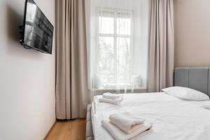 um quarto com uma cama branca e toalhas em Modern Centrally Located Apartment em Cracóvia