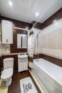 a bathroom with a toilet and a tub and a sink at Современная студия на Броско с шикарным видом in Khabarovsk