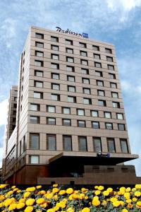 a hotel building with flowers in front of it at Radisson Blu Hotel Chennai City Centre in Chennai