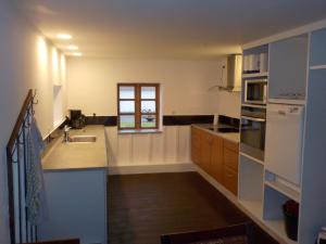 uma grande cozinha com um lavatório e uma janela em Lyngsågaard K em Sæby
