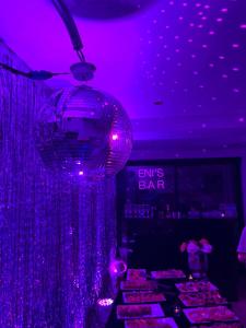 a purple room with a bar with purple lights at Isea Wood Villa in Rrushkull