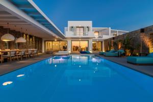 a villa with a swimming pool at night at Splendid Mykonos Luxury Villas & Suites in Mikonos