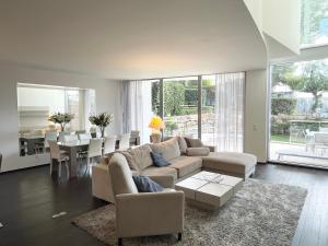 a living room with a couch and a dining room at Modern villa in gated complex Sierra Blanca Marbella in Marbella