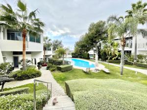 un patio con piscina y palmeras en Modern villa in gated complex Sierra Blanca Marbella, en Marbella