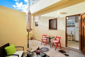 un patio con sedie rosse e un tavolo sul balcone. di CASA MARIGO (OLD HARBOUR) a Chania