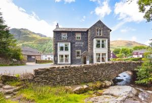 a stone bridge in front of a house at Bridge Hotel in Buttermere
