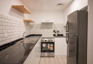 a kitchen with a stainless steel refrigerator and a sink at Walking Distance to Metro! FULL Canal View in Dubai